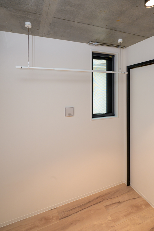 その他部屋・スペース　木目調の床にブラック建具とコンクリート天井を組み合わせた、ス
