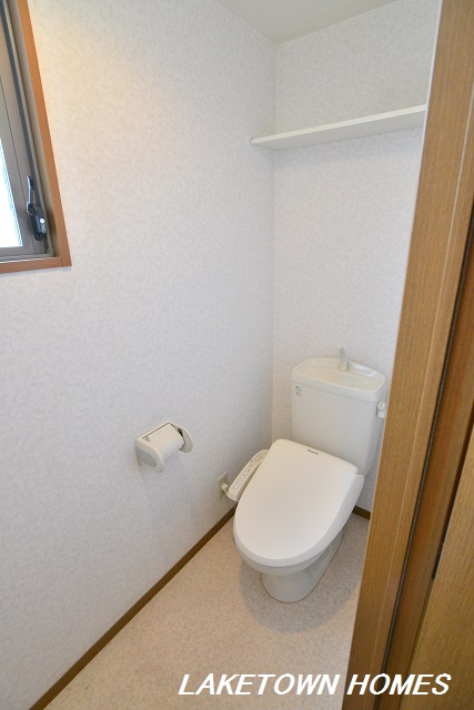 トイレ　上部に収納棚のある温水洗浄便座付のトイレです。