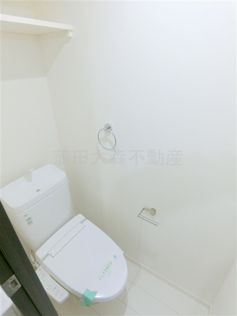 トイレ　上部棚と温水洗浄便座付きのトイレ