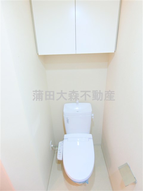 トイレ　吊戸棚と温水洗浄便座付きのトイレ