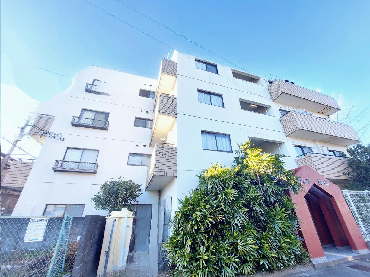 建物外観　白い外壁にレンガ調のバルコニーがおしゃれ