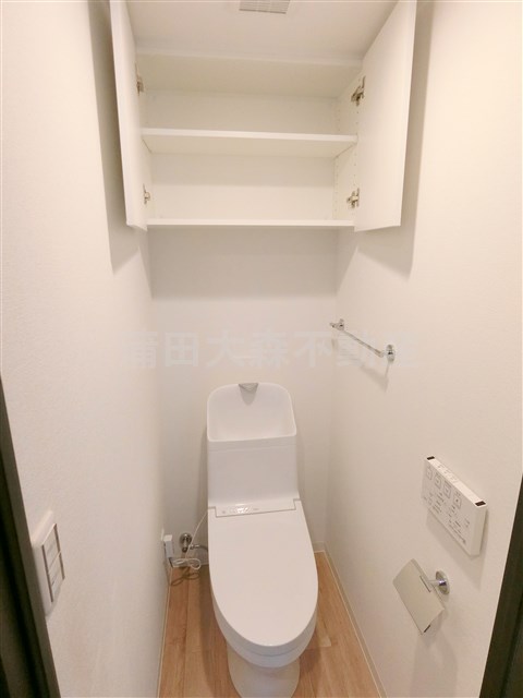 トイレ　ト吊戸棚収納と温水洗浄便座付きのトイレ