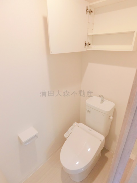 トイレ　吊戸棚と温水洗浄暖房便座付きのトイレ