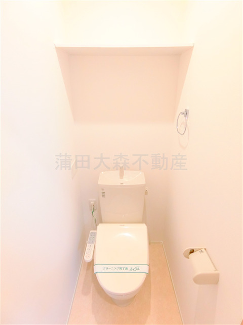 トイレ　棚と温水洗浄便座付きのトイレ