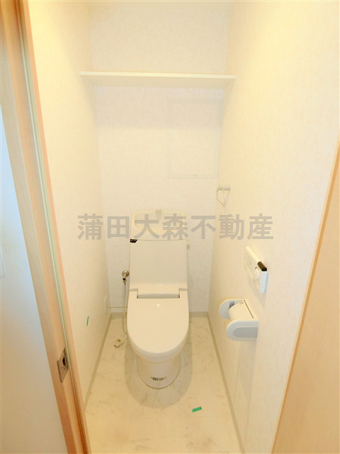 トイレ　棚と温水暖房便座付きのトイレ