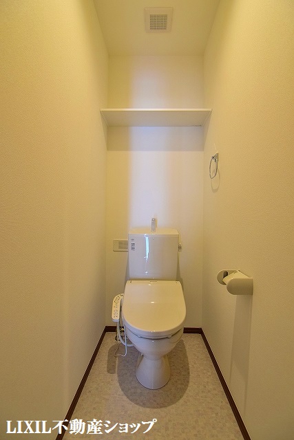 トイレ　上部に収納棚のある温水洗浄便座付のトイレです。