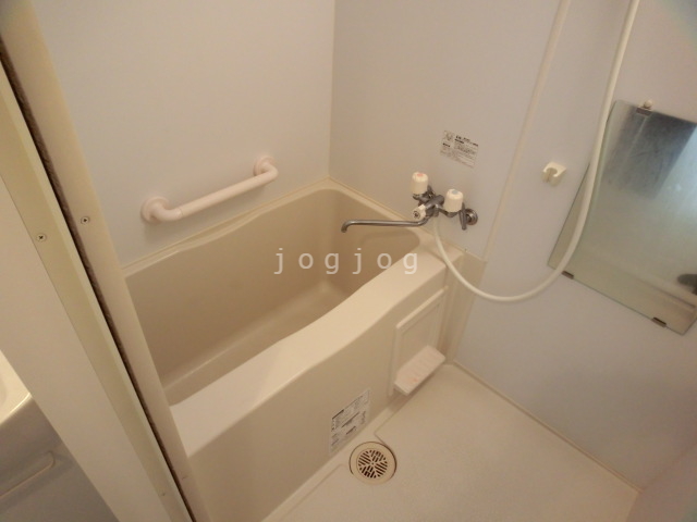 バス・シャワールーム　ボトルを収納可能な棚と手すりを完備したお風呂です。