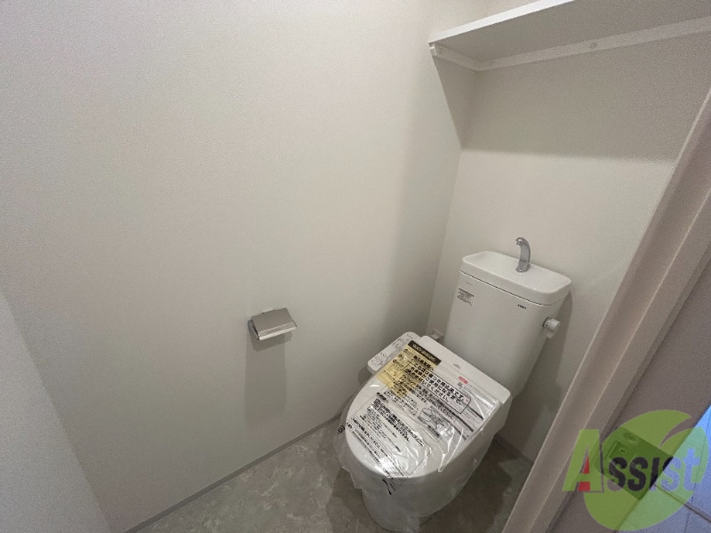 トイレ　トイレには温水洗浄便座がついています。上段に棚もありますね。