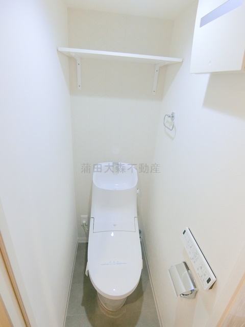 トイレ　棚と温水洗浄便座付きのトイレ