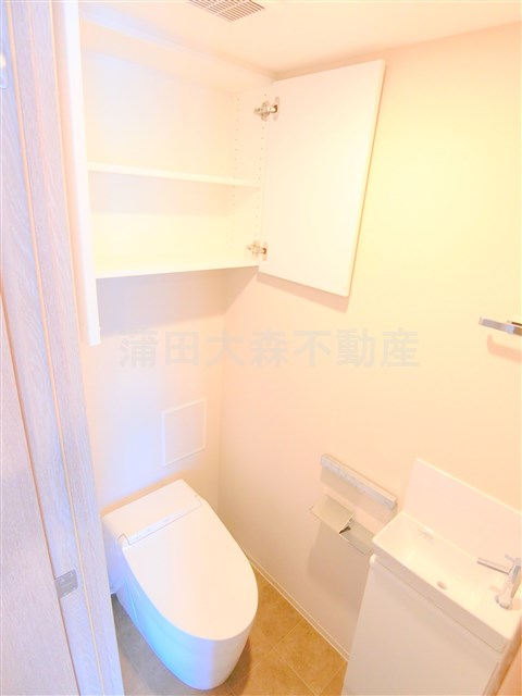トイレ　棚収納と温水洗浄便座付きのトイレ