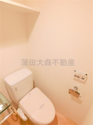 トイレ　棚と温水洗浄便座付きのトイレ