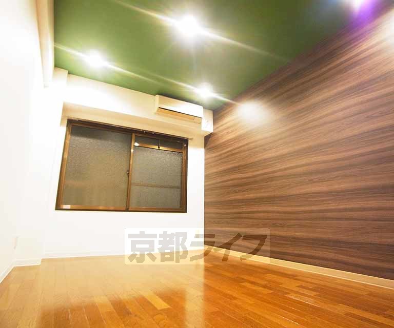 居室・リビング　木目と濃いグリーンのアクセントクロスが落ち着きと高級感を演出