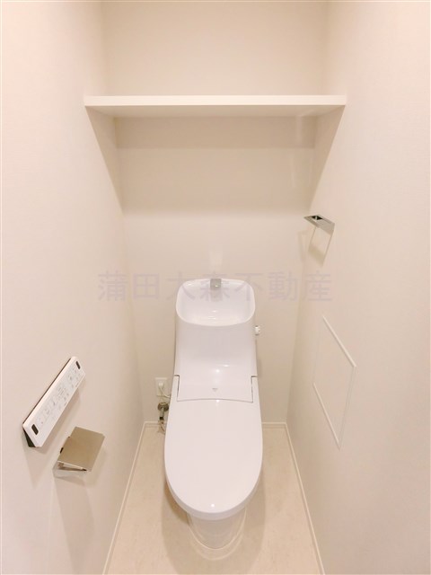 トイレ　棚と温水洗浄便座付きのトイレ