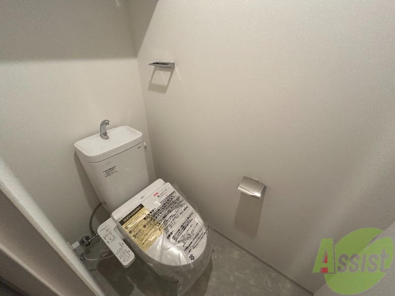 トイレ　トイレには温水洗浄便座がついています。上段に棚もありますね。