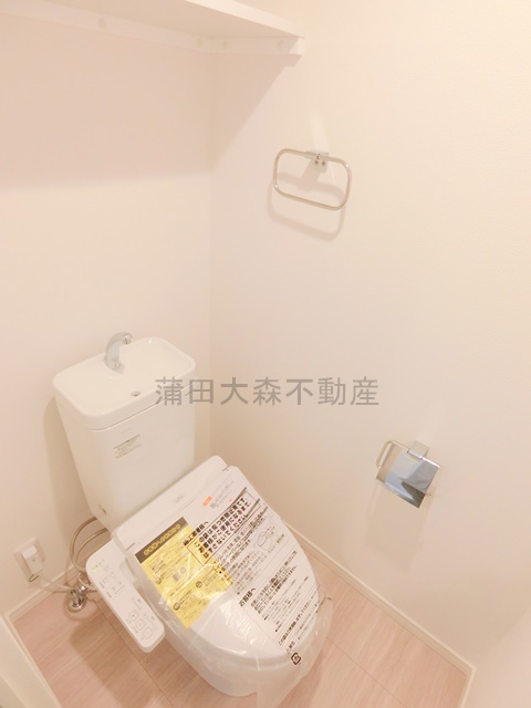 トイレ　棚と温水洗浄便座付きのトイレ