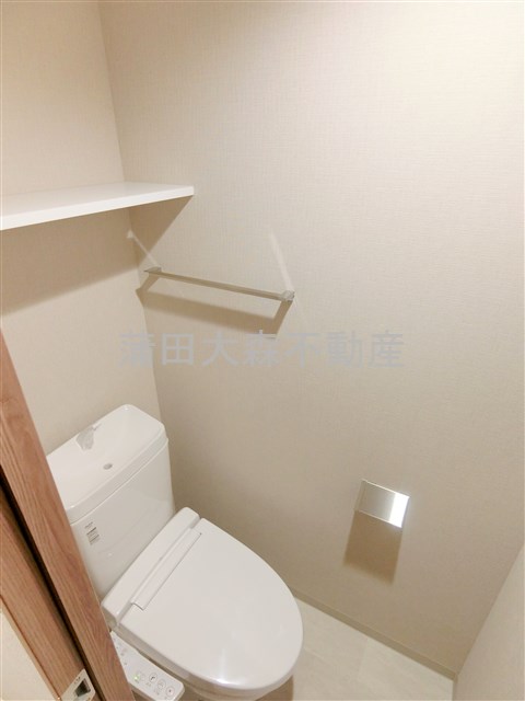 トイレ　棚と温水洗浄便座付きのトイレ