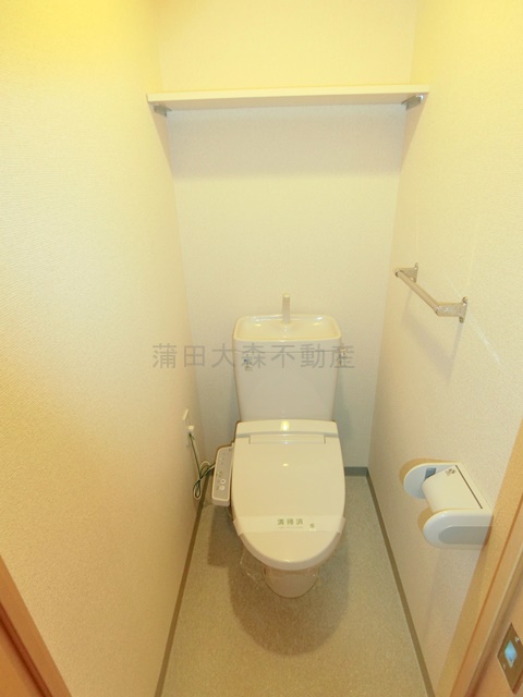 トイレ　棚と温水洗浄便座付きのトイレ