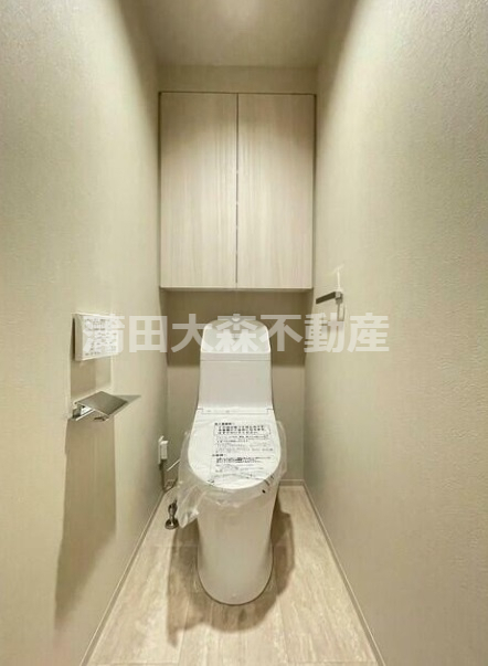 トイレ　吊戸棚収納と温水洗浄便座付きのトイレ