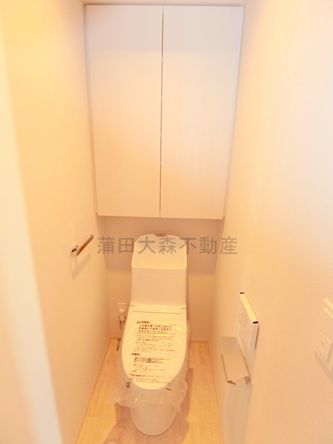 トイレ　吊戸棚収納と温水洗浄便座付きのトイレ