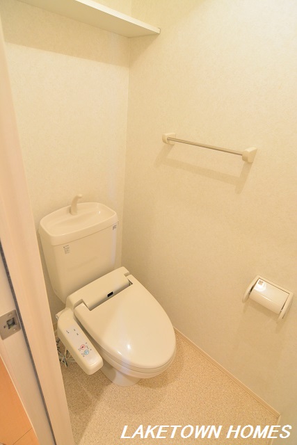 トイレ　上部に収納棚のある温水洗浄便座付のトイレです。