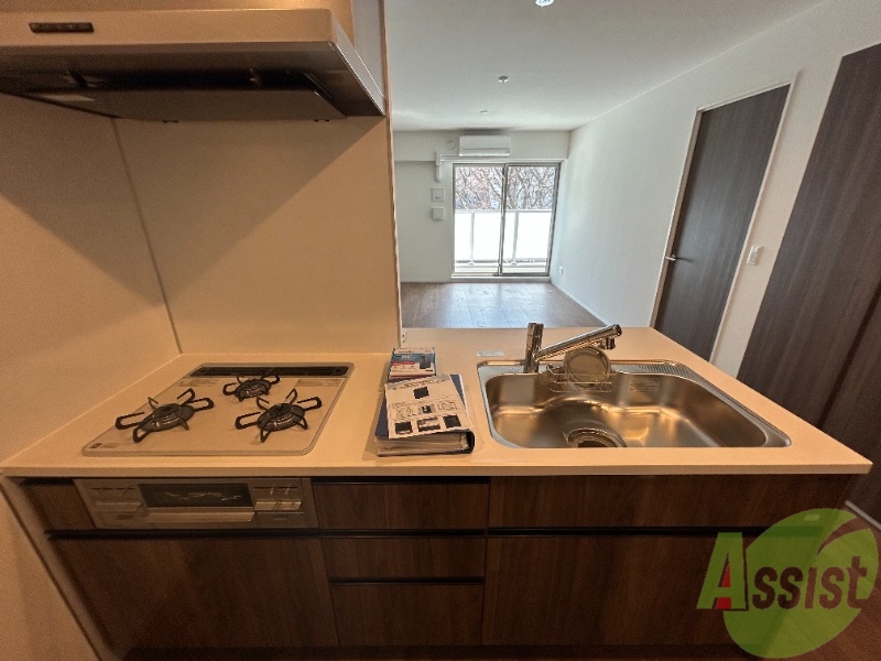 キッチン　３口のガスコンロとグリルが設置済みのシステムキッチンです。