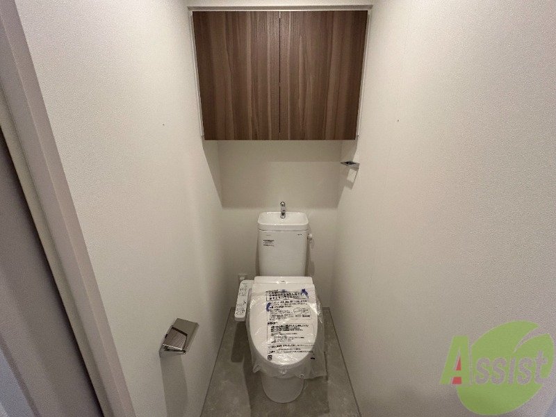 トイレ　トイレには温水洗浄便座がついています。上段に棚もありますね。