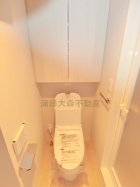 トイレ　吊戸棚収納と温水洗浄便座付きのトイレ