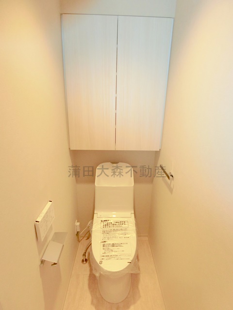 トイレ　吊戸棚収納と温水洗浄便座付きのトイレ