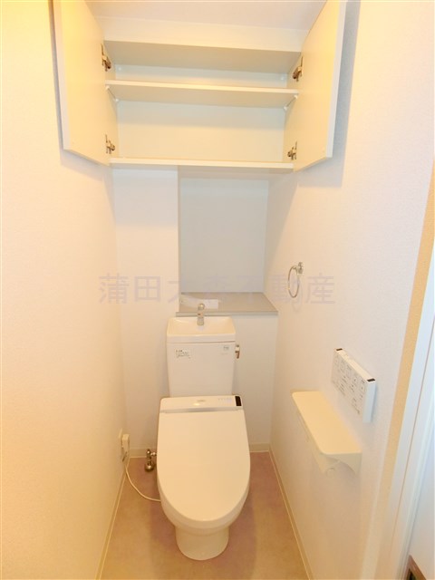 トイレ　吊戸棚収納と温水洗浄便座付きのトイレ