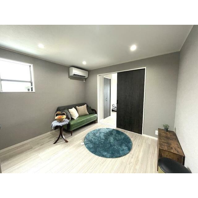 居室・リビング　グレーの壁紙×ダーク系カラーのウッド調を取り入れ、居心地の良