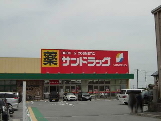 ドラックストア　サンドラッグ島崎店（ドラッグストア）まで883m