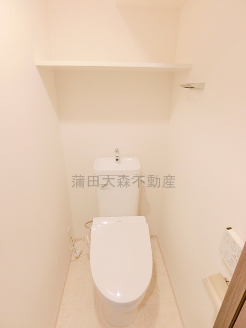 トイレ　棚と温水洗浄便座付きのトイレ