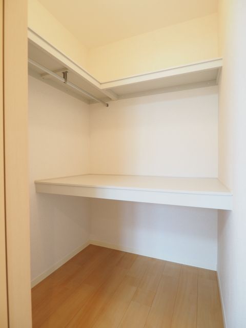 収納　ハンガーパイプと机棚、枕棚を配したウォークインクローゼット