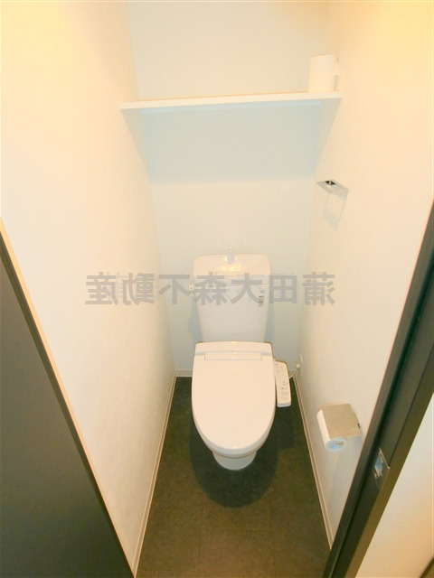 トイレ　棚と温水暖房便座付きのトイレ