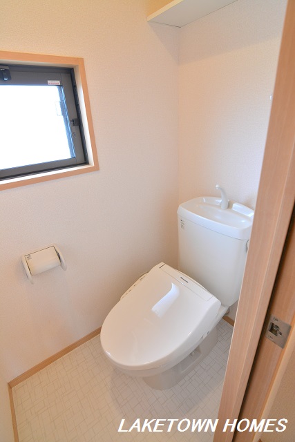 トイレ　小窓があり上部に収納棚のあるトイレです。