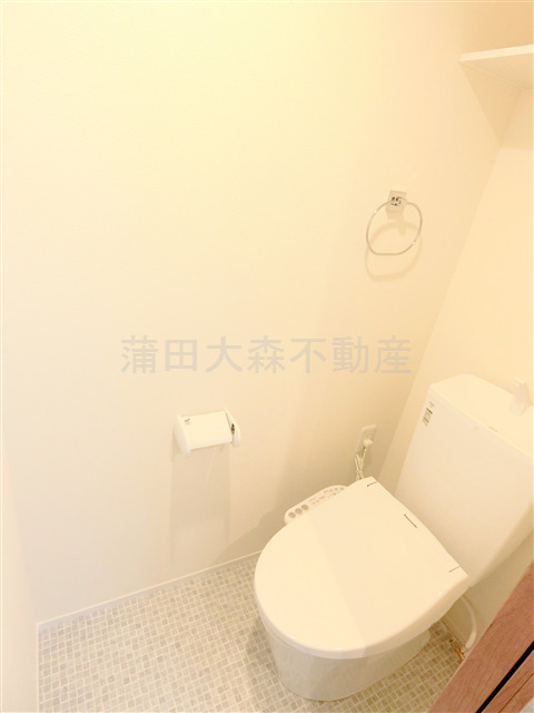 トイレ　棚と温水洗浄便座付きのトイレ