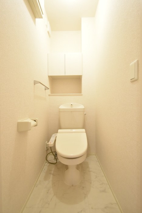 トイレ　温水洗浄暖房便座トイレ。戸棚がありトイレットペーパーや掃除道