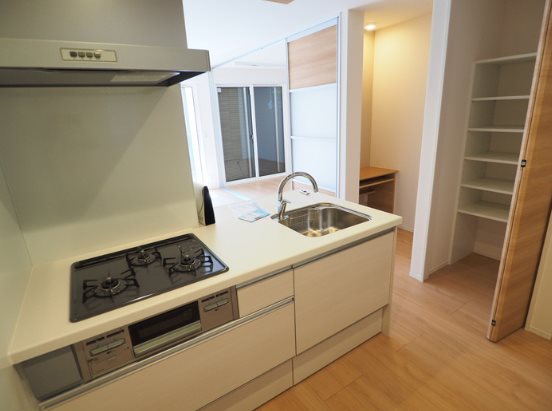 キッチン　3口コンロのシステムキッチン。パントリー収納があり、キッチン