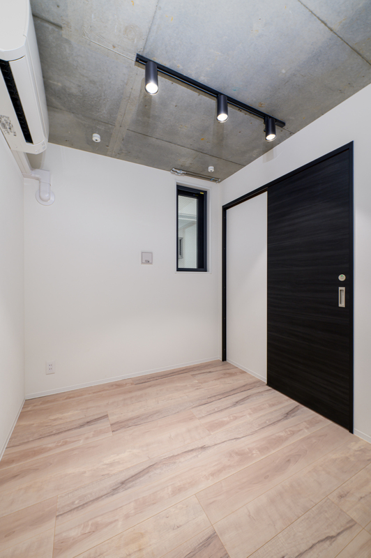 その他部屋・スペース　木目調の床にブラック建具とコンクリート天井を組み合わせた、ス