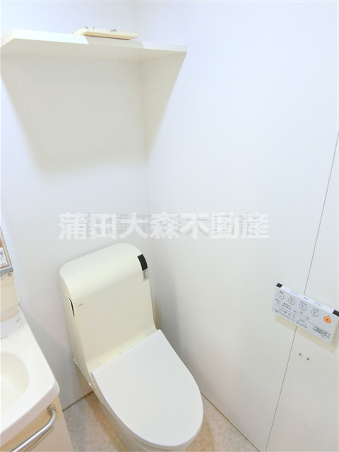 トイレ　棚と温水洗浄便座付きのトイレ