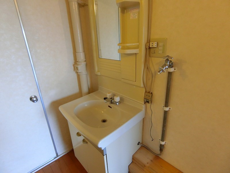 洗面設備　独立洗面台付です。天井にカーテンレールがあり、洗面部分と玄関