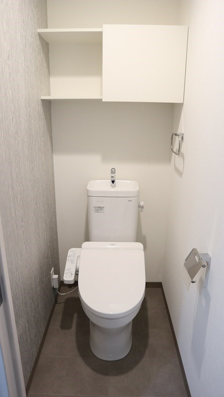 トイレ　温水洗浄便座です。上部の収納棚を活用して、トイレを清潔に保て