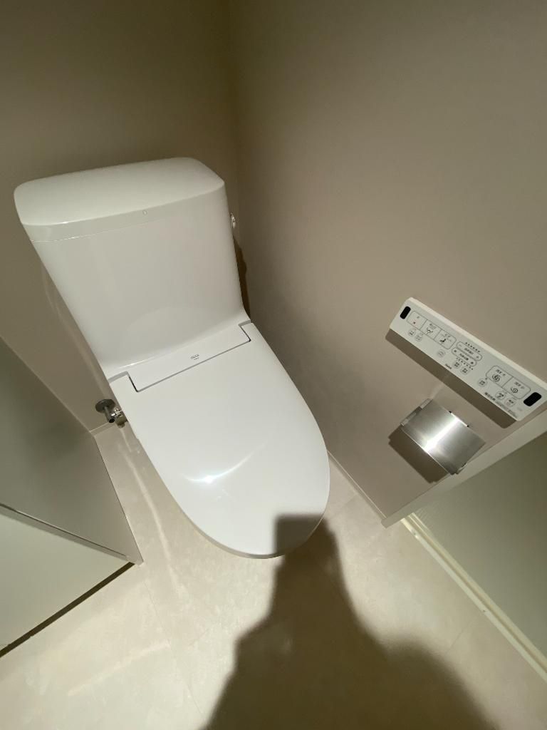 トイレ　吊戸棚と温水洗浄便座付きのトイレ