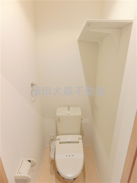 トイレ　棚と温水洗浄便座付きのトイレ