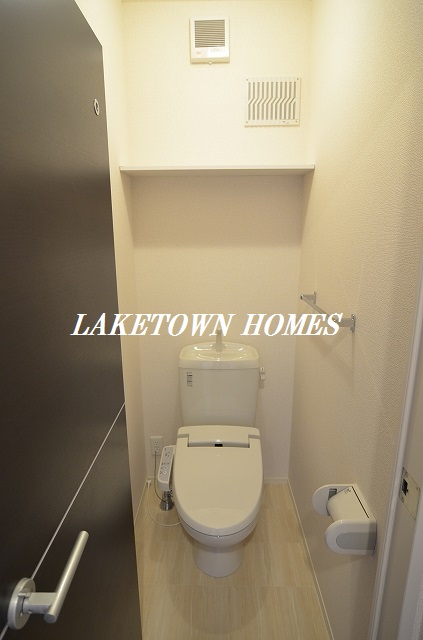 トイレ　上部に収納棚のある温水洗浄便座付のトイレです。